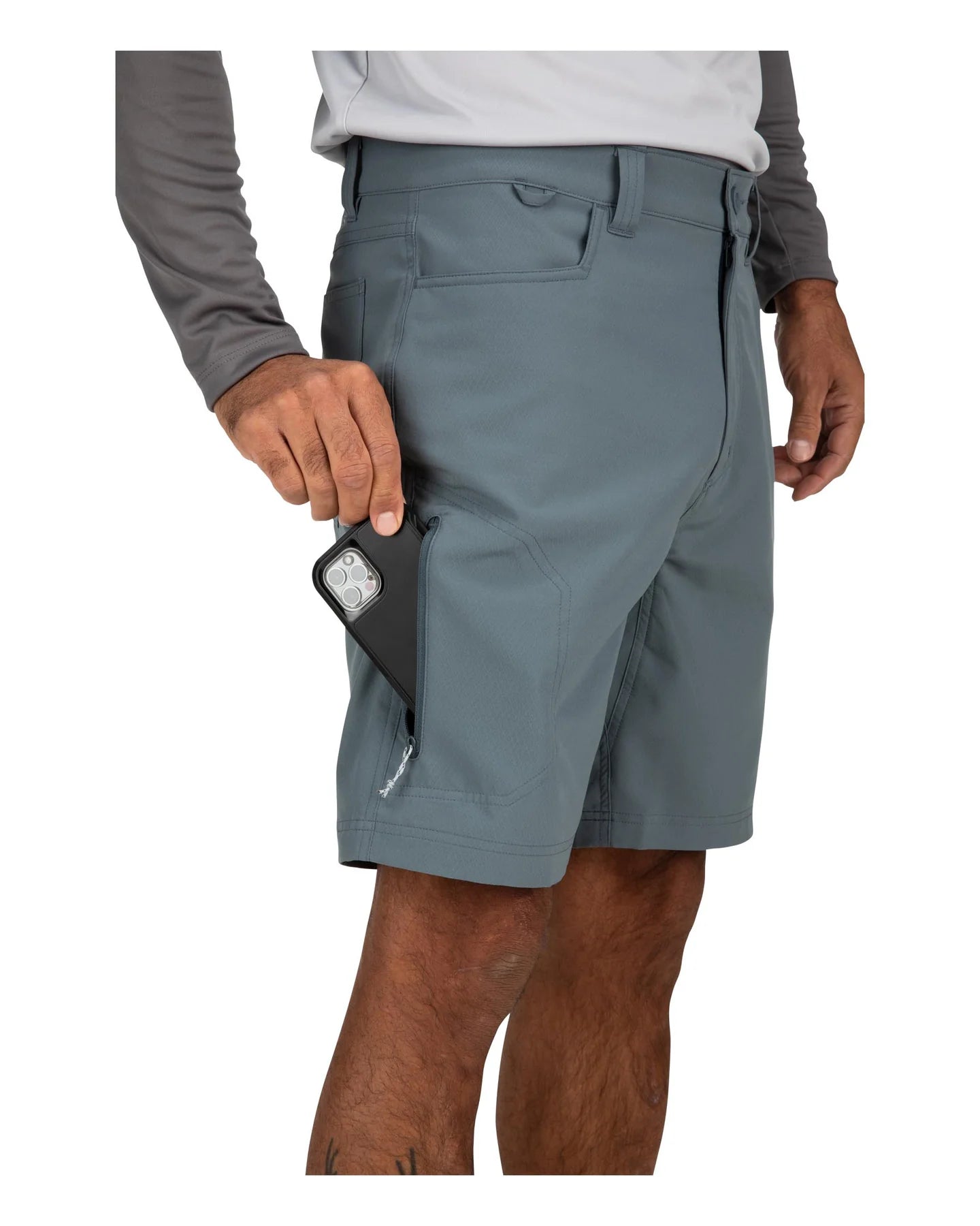 Man wearing blue shorts placing an item in pocket