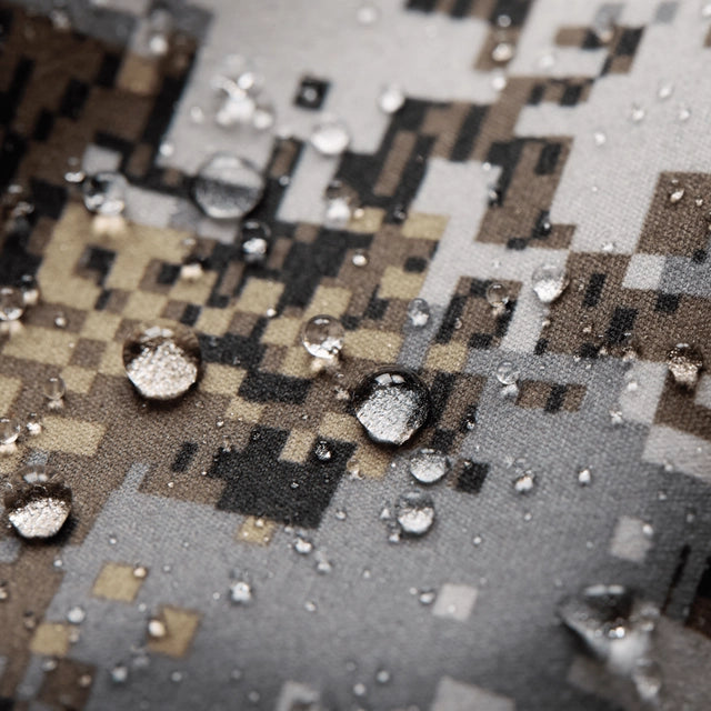 Close-up of water droplets on a textured surface with a pixelated pattern.