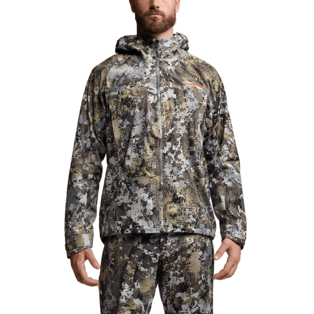 Camouflage jacket and pants worn by a person on a white background