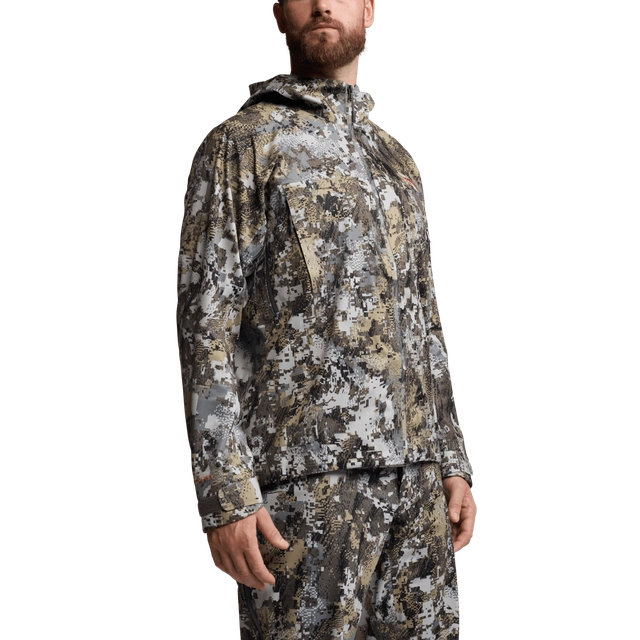 Person wearing a camouflage jacket and pants on a white background