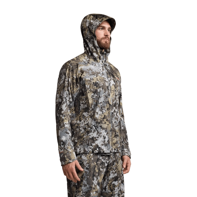 Person wearing a camouflage hoodie and pants on a white background