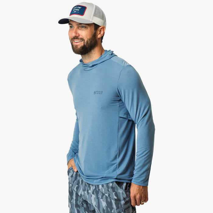 Man wearing a blue hoodie and camouflage shorts on a white background