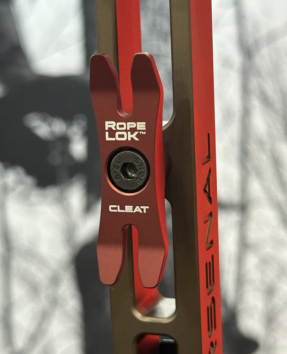Red rope cleat with 'Rope Lok' branding against a blurred natural background