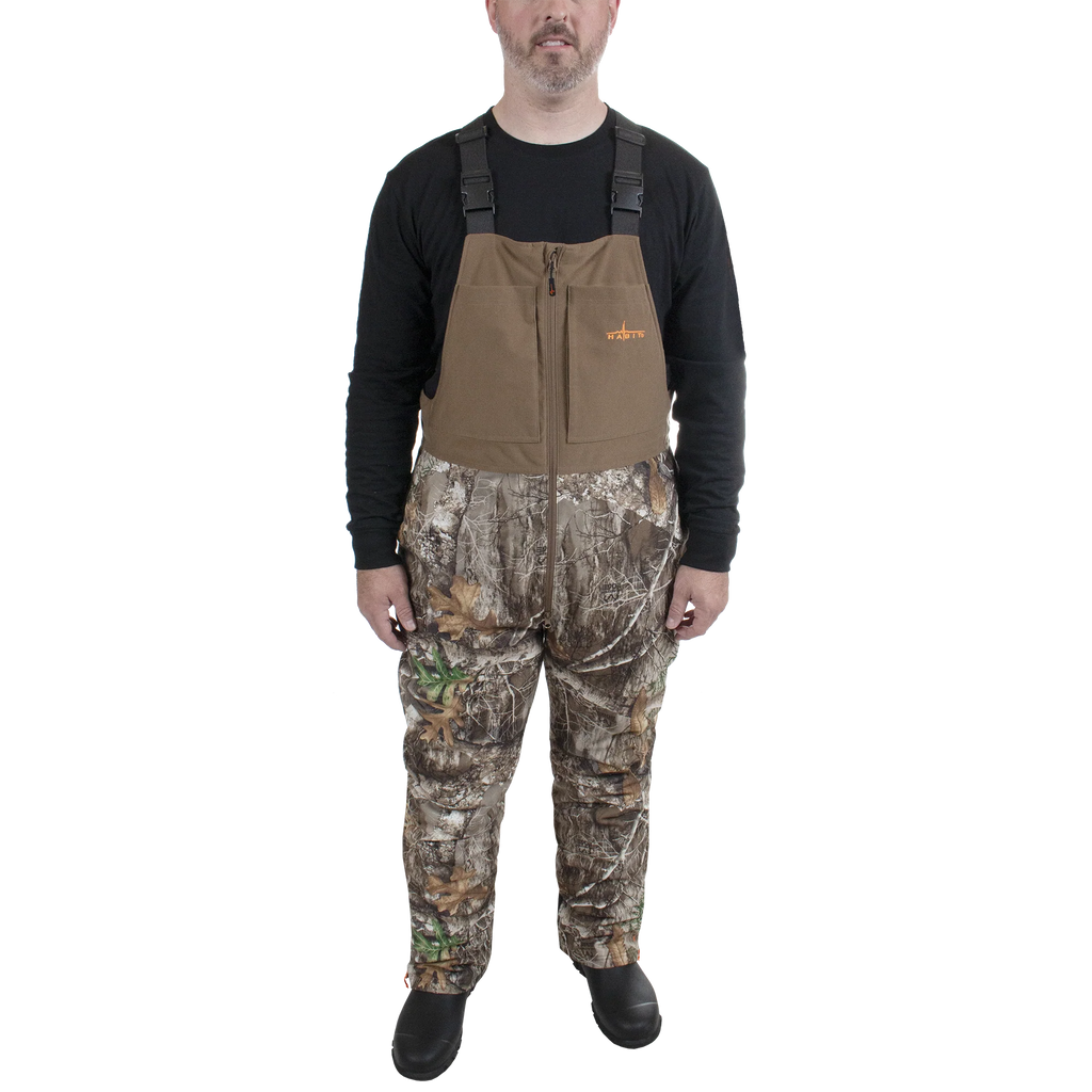Man wearing camouflage hunting pants and a brown vest on a white background