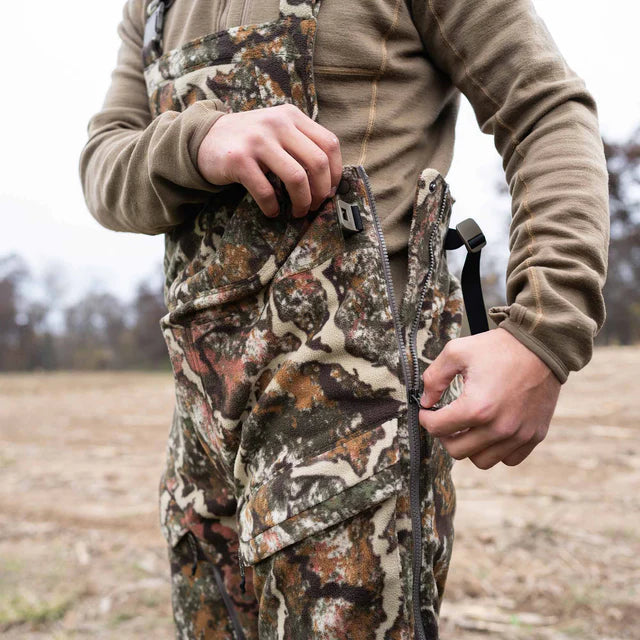 Person wearing camouflage hunting pants with a blurred natural background