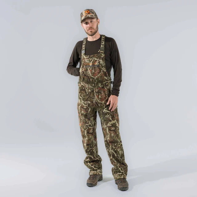 Man wearing camouflage overalls and a cap on a white background