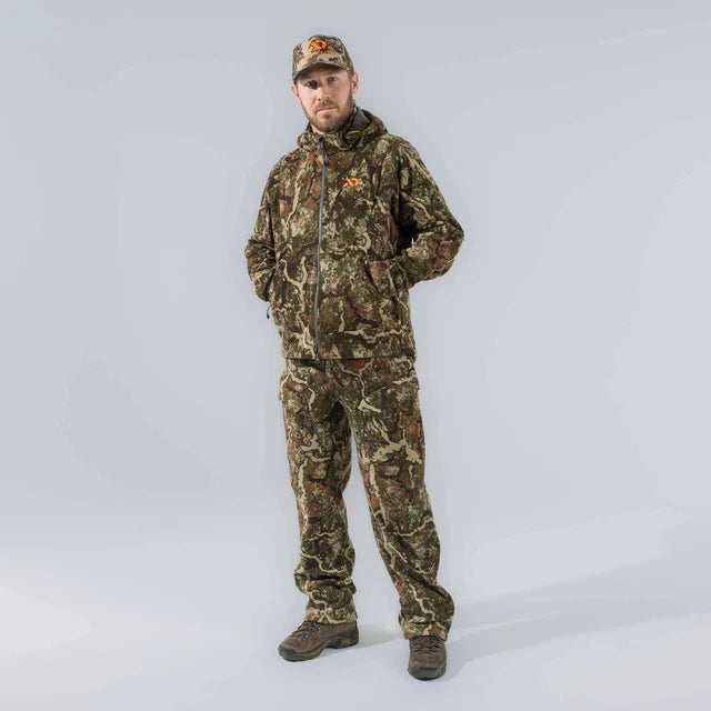 Person wearing full camouflage hunting outfit with a cap on a white background