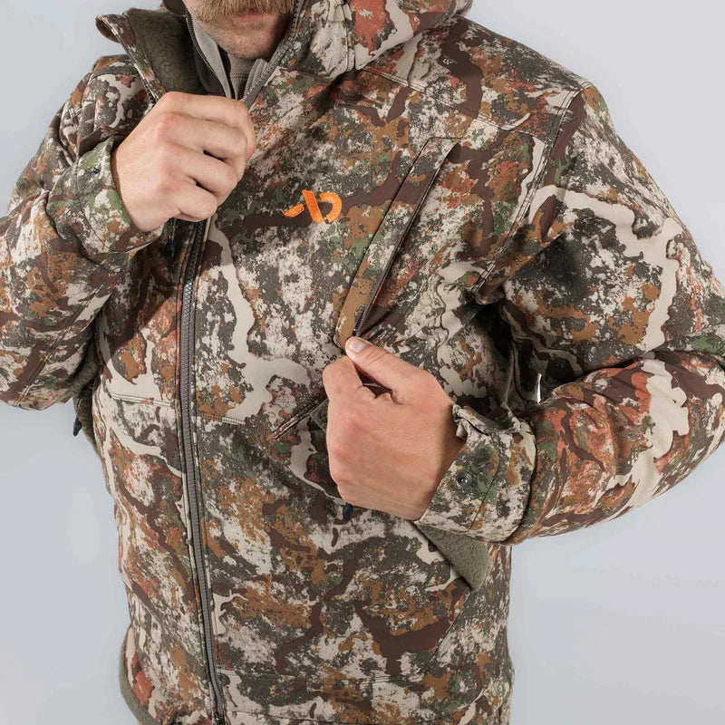 Person wearing a camouflage jacket with a brand logo on a light gray background