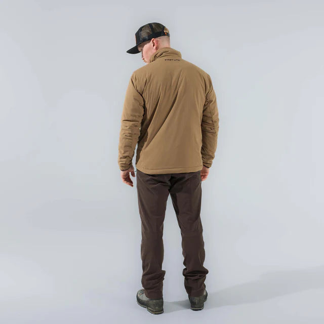 Man wearing a brown jacket and dark pants on a white background
